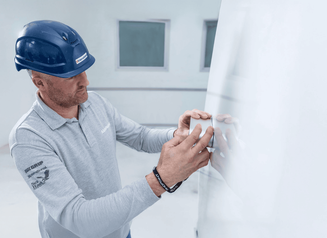 Marine coatings technician applying or inspecting a finish on a boat hull