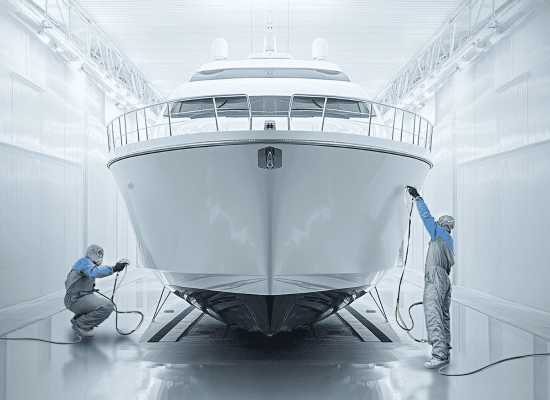 Close-up of a white yacht or boat viewed from the bow inside a coating facility