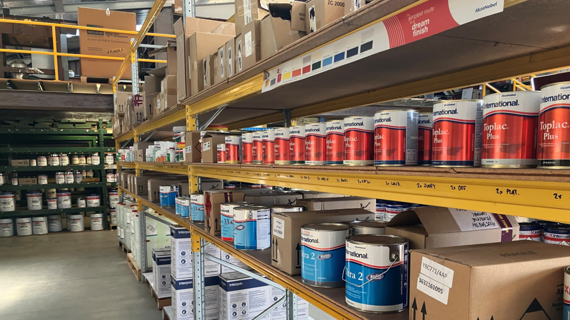 Shelves stocked with Awlgrip and Awlmix marine coating products inside the Protective Coating Supplies warehouse in Tasmania.