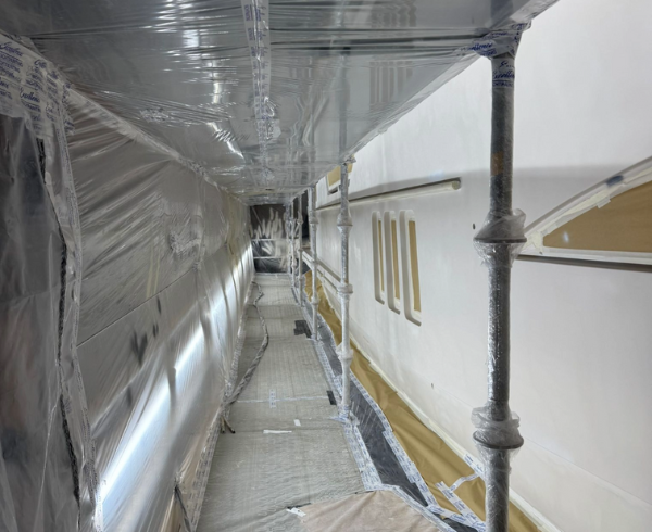 Superyacht hull masked and scaffolded for coating preparation